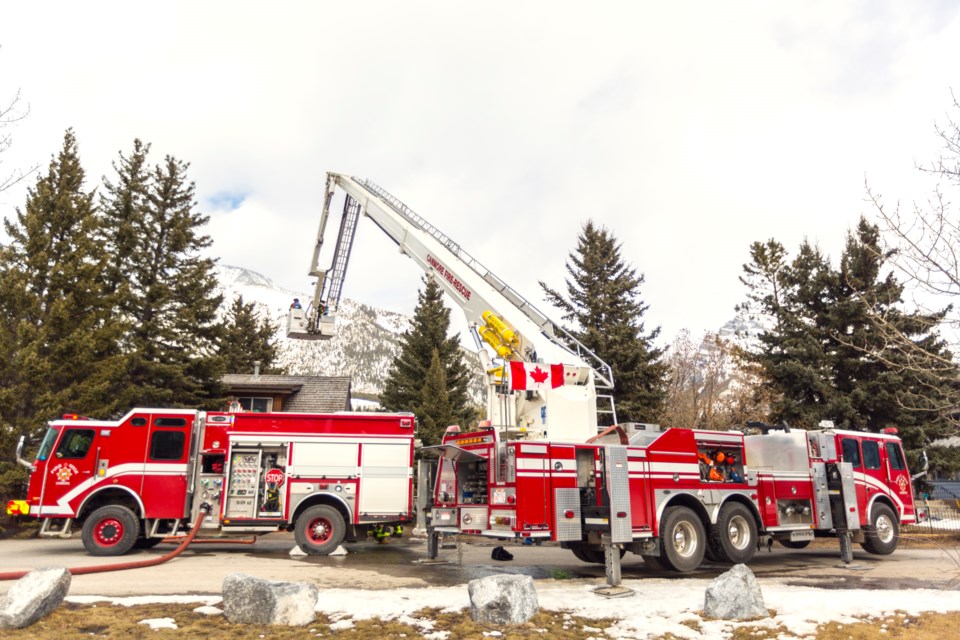 Canmore Fire Rescue uses an aerial boom to check a house adjacent to Bow Valley Trail in Canmore for hotspots after a small explosion and fire occurred on Wednesday (March