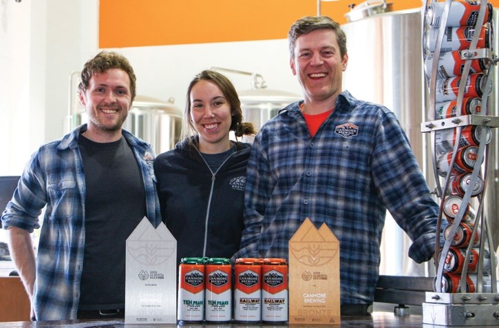 Nathan Skillen, head brewer (left), Mary Lusty, brewers assistant and Brian Dunn of Canmore Brewing Company, with award-winning beer.