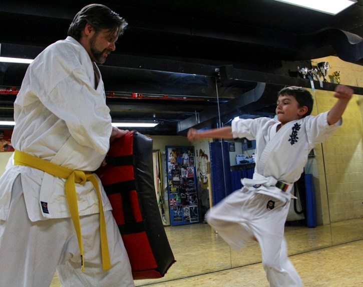 Francois Pace and his son Xavier Pace practise their kicks at the Banff Kyokushin Karate Club dojo in Banff Tuesday (March 27).