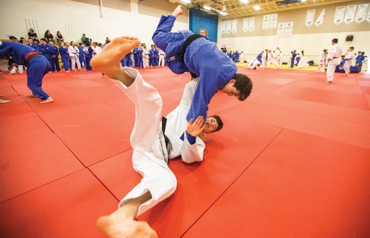 Mckenzie Morgan in blue and David Wu in white practice some judo throws at Lawrence Grassi Middle School in Canmore on Saturday (April 14).