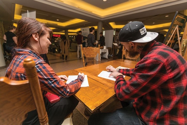 Jessica Morconbe, left, and Matt Jackson fill out application forms at The Job Centre hiring fair at Cascade Mall in Banff on Thursday (May 3). Over 500 jobs were available