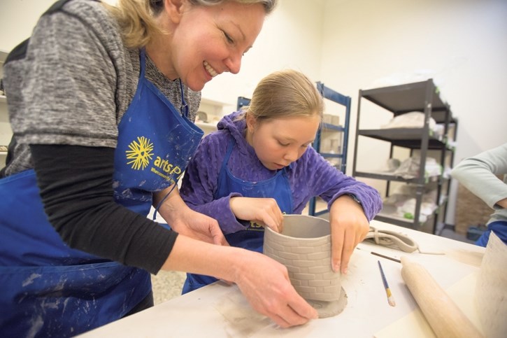 Leah Fradette, left, receives instructions from Erin Murphy on how to score her clay plant pot base so walls can be glued on during last year’s Pottery Palooza at artsPlace