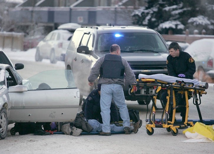 An armed robbery suspect is treated by EMS after being shot by Canmore RCMP in connection with three robberies in three days. Eyewitness accounts say the male fired two shots 