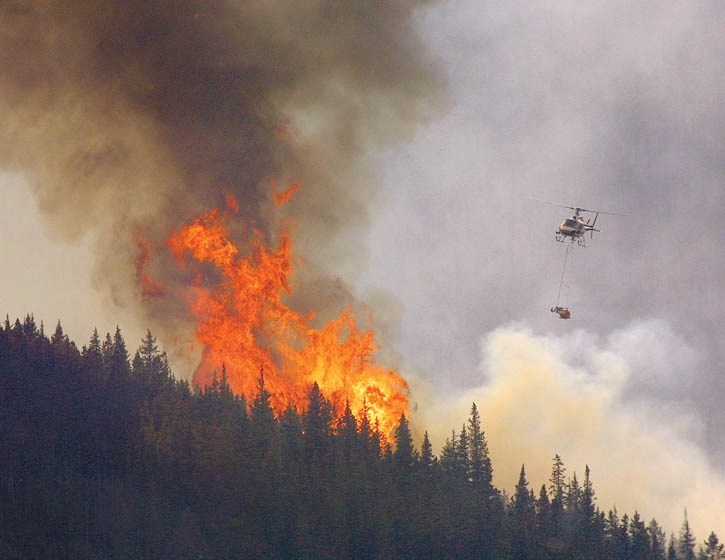 A helicopter ignites a prescribed fire in the Lake Minnewanka area.
