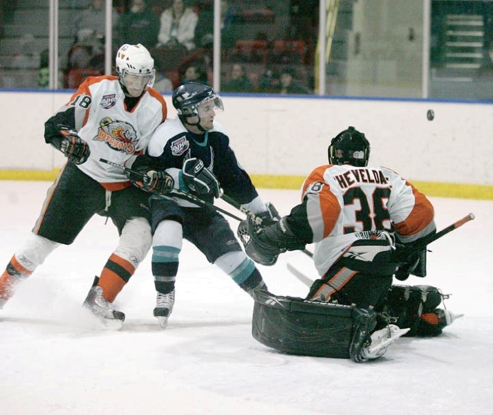 Dragons defenceman Brennan Baxandall leans on Eagles forward Brian Doust as Drumheller overpowers Canmore in the second period of Tuesday night’s (Feb. 15) AJHL matchup at
