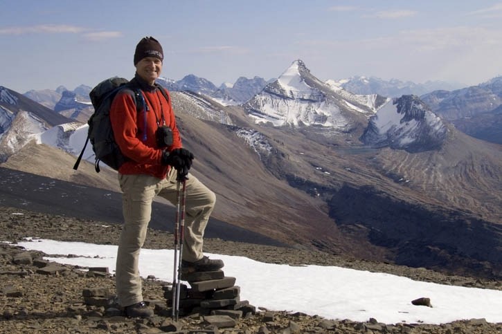 Ray Norman smiles during a break on Tangle Ridge, en route to leading a Meanderthals group to the summit of Mount Nigel, in the background.