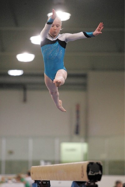 Illusions gymnast Abby Houck leaps above the beam during the Summit Invitational at the Canmore Rec Centre, Friday (May 6). Houck tied for first in the discipline and was