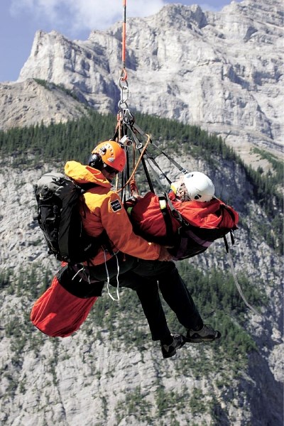 Parks Canada public safety specialist Steve Holeczi brings Calgarian Jonathon Lytton down to safety after a climbing accident on Cascade Mountain (seen in background) near
