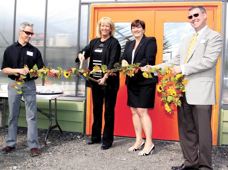MLA Janis Tarchuk, centre left, and Mayor Karen Sorenson cut a garland at the official opening of the Banff Community Greenhouse, Monday (June 27). Bart Donnelly, far left,