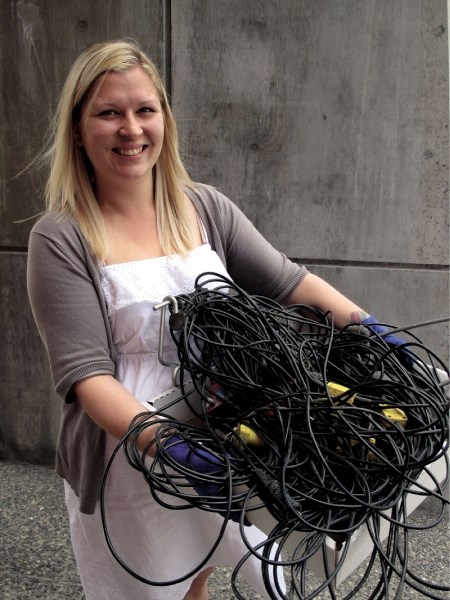 Collections manager Amanda Sittrop holds a mysterious tangle of cords, perhaps used in seismic work. As part of the museum’s Deep Research project, Sittrop hopes to answer
