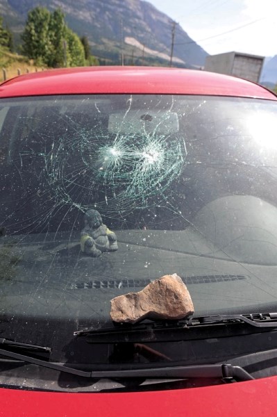 The smashed window of a car, and the rock that did it, parked on Glacier Drive in Canmore, Saturday (Aug. 27). Several vehicles were damaged in this way over the course of