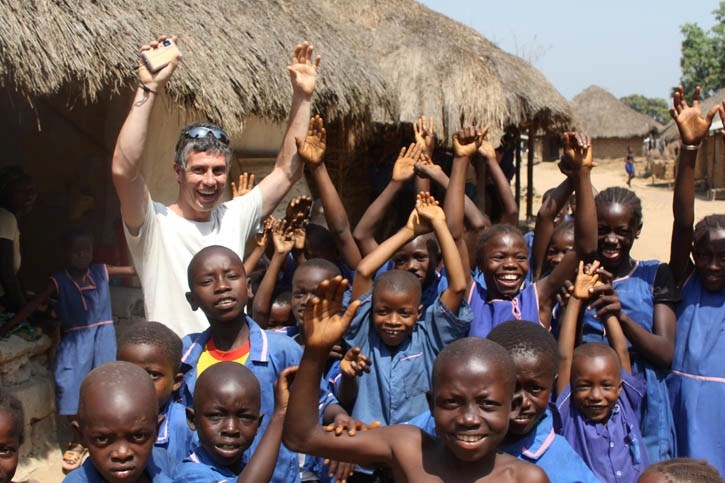 Alistair Darichuk is greeted by several schoolchildren in Sierra Leone. He and several Bicycle Cafe employees took part in a 600 km Cause Canada expedition across the country.
