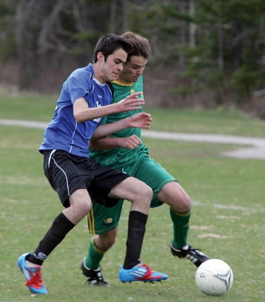 Spencer Postman battles for control of the ball during the Canmore Collegiate High School Crusaders’ 1-1 tie against High River (May 9).