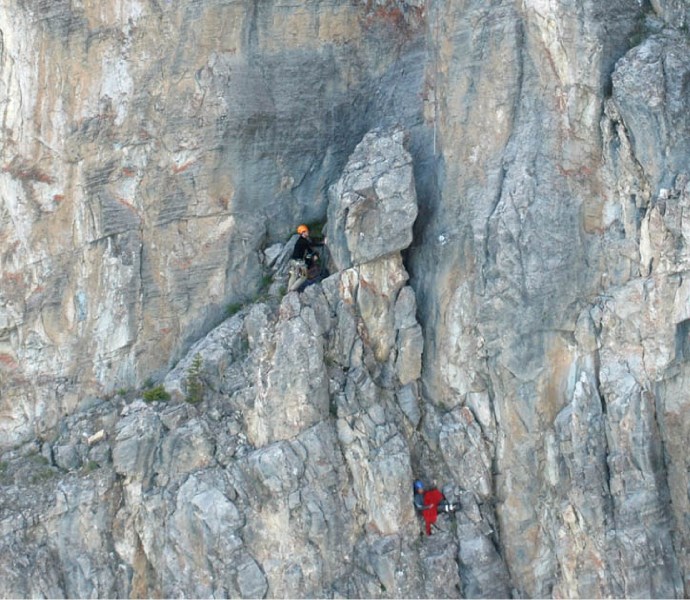 An injured climber (lower right) waits for a helicopter rescue from Yamnuska.