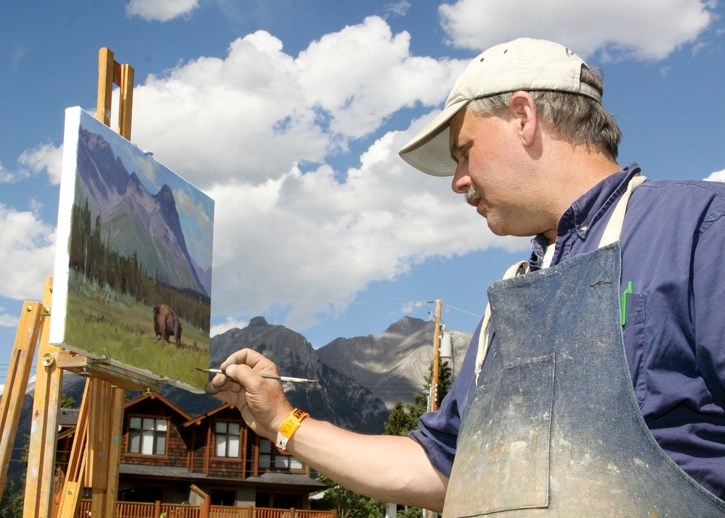 The inaugural Banff National Park artist-in-residence Dwayne Harty puts the finishing touches on a painting of a lone bison in front of Ehagay Nakoda Aug. 6 during the