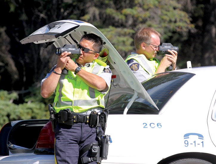 RCMP Cst. Mike Chin, left, and Cpl. Chris Blandford with handheld laser units on the Trans-Canada Highway, Sunday (Aug. 26).