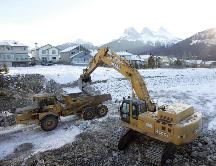 Construction crews move boulders in Cougar Creek in Canmore as they repair and reinforce the area after it was significantly washed out last year.