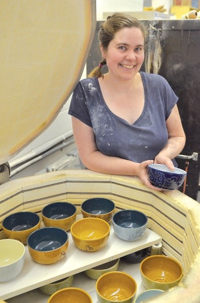 Katie Borrowman of Of Cabbages and Kings pottery studio stands at the kiln with her work. The studio is donating 120 bowls to a chili fundraiser in Canmore March 8.