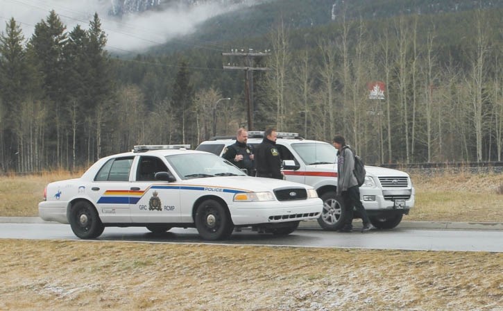 Law enforcement personnel speak with a youth about the dangers of trespassing on CP Rail property near the Canmore Rec Centre, Monday (April 29) during Railway Safety Week.