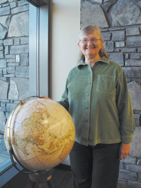 Mary Dumka with one of the globes being placed in libraries in honour of long-time Canmore councillor, Andr