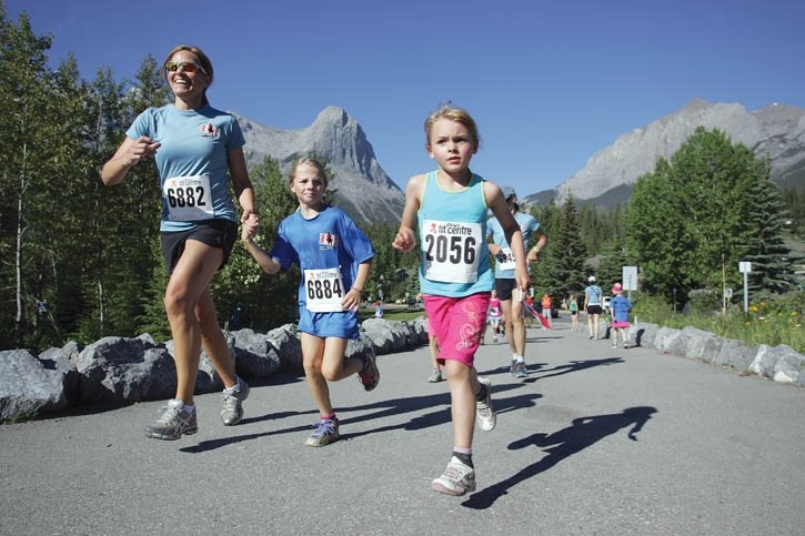 (L to R) Carolyn Robertson, Joanna Robertson and Aria Grandi run to a picture perfect backdrop as they head for home in Monday’s Canada Day Fun Run.