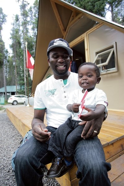 Sheldon Fisher and his son Shiloh relax in front of a new Parks Canada oTENTiks unit.