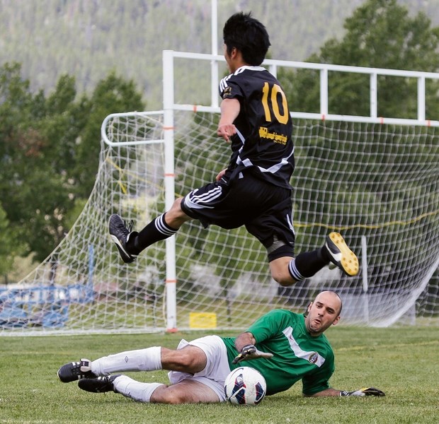 Nathan Troy (left) of Pump and Tap Tavern slides in desperation across the goal line to save a sure goal by Banff Sushi House during a match at the Banff Rec Grounds on