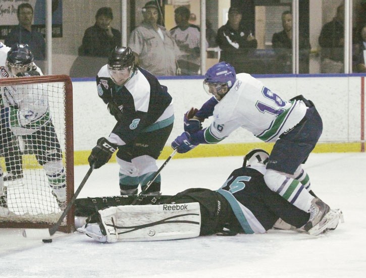 Canmore Eagles defenceman Brett Schimmel bails out goalie Ryan Ferguson by clearing a puck off the goal-line during an exhibition game against the Calgary Canucks, Tuesday