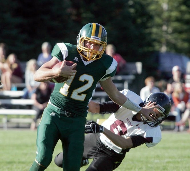 Bow Valley Wolverine Mark Grain fends off a tackle during Friday’s (Sept. 20) high school football matchup against Rundle College.