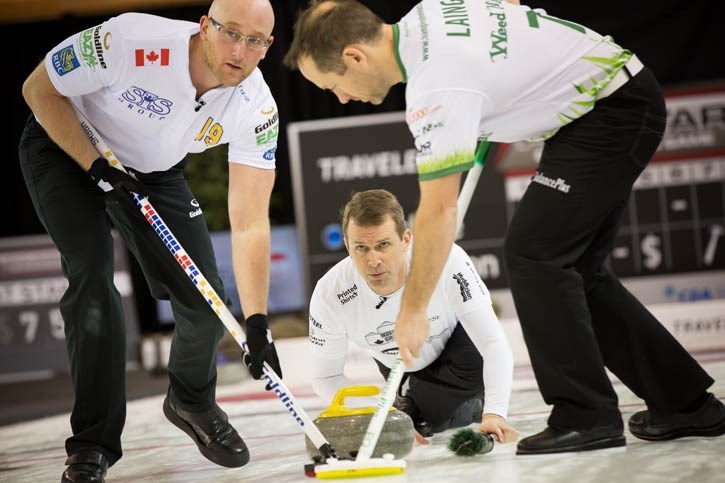 Skip Jeff Stoughton delivers as Ryan Harnden, left, and Brent Laing sweep during Travelers All-Star Curling Skins Game action in Banff, Saturday (Jan. 11).