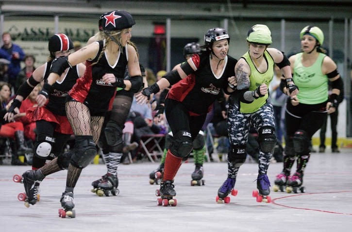 BanisHer (centre) leans on Gypsy Jo while teammate Creeps Up sOnya, left, goes around the outside during Saturday’s (April 26) roller derby bout.
