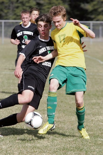 Josh Lewis, right, goes shoulder to shoulder as he battles for the ball during Wednesday’s (May 14) high school soccer matchup between Canmore Collegiate and Okotoks’ Holy