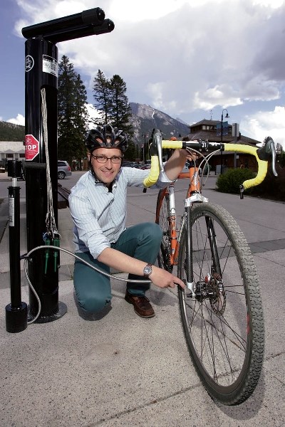 Town of Banff planner Keith Batstone shows off the new Central Park bike repair station, which includes tools, air and QR codes to access to repair instructions.