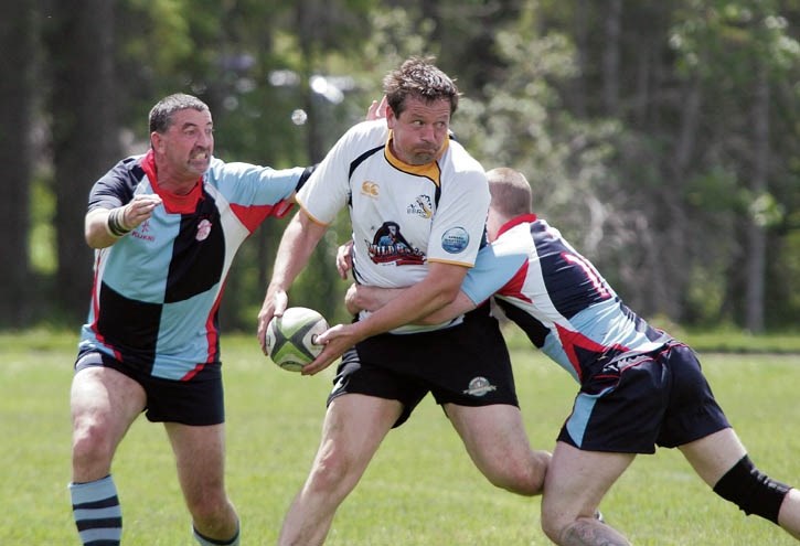 Mark Hooper looks to swing the ball wide and evade a pair of tacklers during the Banff Bears’ 46-19 loss to the Canucks at the Banff Rec Grounds, Saturday (June 28).