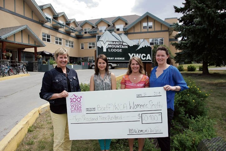 Banff YWCA’s Connie MacDonald, left, Paula Krupa and Linda Chisholm receive $10,900 from 100 Women Who Care founder Keltie Patterson, right. The money, raised through the