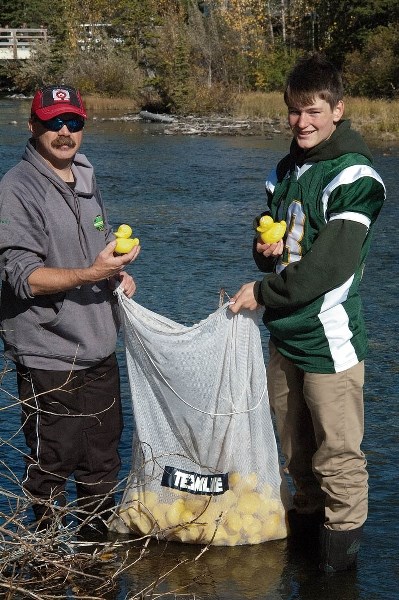 Jeff Jantz and Thomas Hunt collect rubber duckies at the Bow Valley Wolverines’ duck race fundraiser, Sunday (Sept. 26).