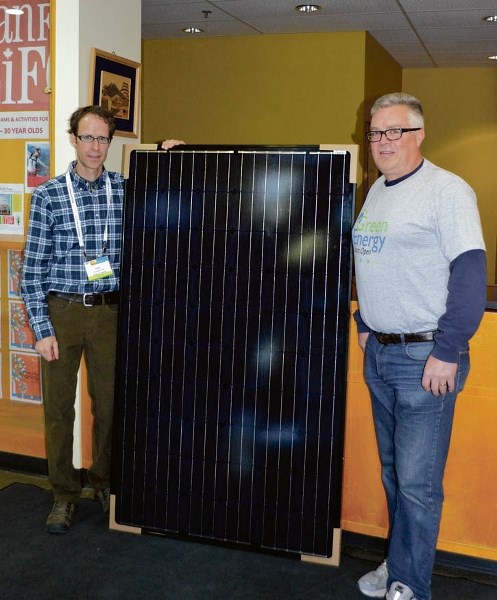 Chad Townsend, Town of Banff environmental coordinator (L) and Doug Webb, vice-president operations at Decentralised Engery Canada, stand next to a sample solar power panel