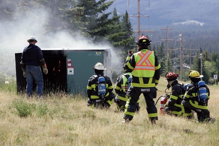 Firefighters and Fortis workers work to extinguish a fire and restore power after an electrical switching box caught fire on Elk Run Boulevard in Canmore Tuesday morning