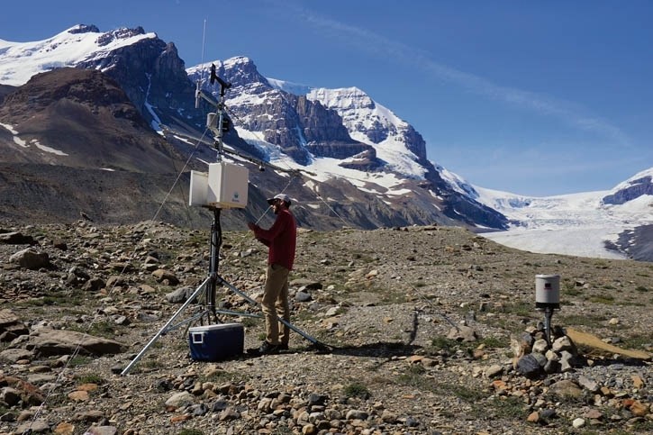 Dr. Jonathan Conway collects data from an instrument site near the toe of the Athabasca Glacier in Jasper National Park.