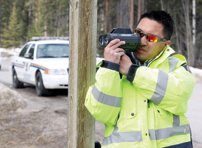RCMP Cst. Mike Chin with a laser unit. Police will have extra patrols on the highway for the August long weekend.