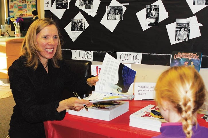 Local childrens’ author Mandi Kujawa signs a copy of her new debut book Jacqueline The Singing Crow on Friday (Nov. 6) at Banff Elementary School.
