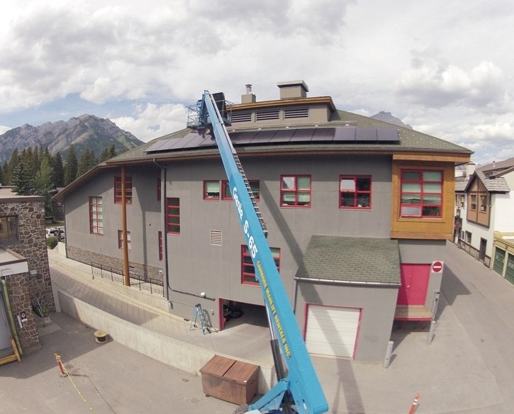 Workers install solar panels on Banff Town Hall in 2013 in a move to reduce energy consumption and greenhouse gas emissions.