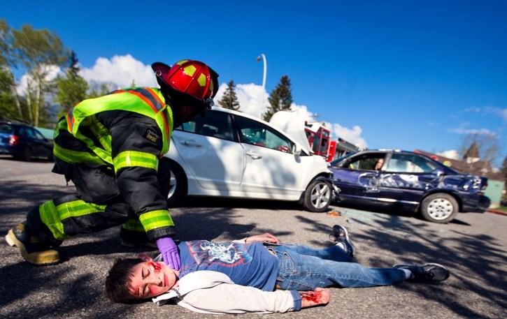 Aaron Smith, bottom, plays the part of a passenger ejected from a car crash as part of the PARTY Program at the Canmore Hospital in Canmore, Wednesday (April 27).