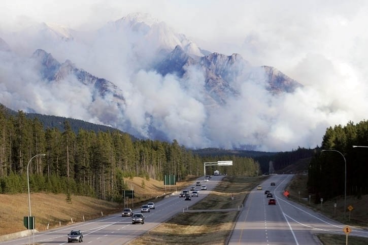 Motorists on the Trans-Canada Highway drive by a dramatic prescribed burn on the Sawback Range in Banff National Park in 2014.