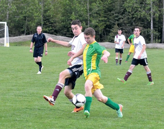 Crusader Jackson Howatt, front, battles for the ball against the Foothills Composite Falcons, Monday (May 30).