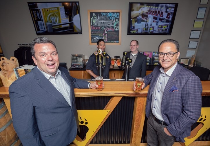 Robert Flatt, left, president of the Grizzly Paw Brewing Company and a member of the Alberta Small Brewers Association board of directors, shares a beer with Alberta Finance
