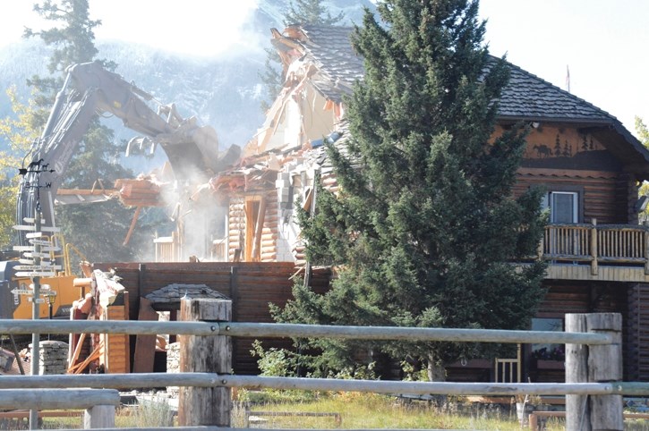An excavator smashes through the Rafter Six Ranch’s main lodge on Monday (Sept. 12).