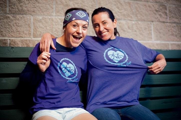 Charity riders Brianna Roth, left, and Christy Little show off their shirts at Harvest in Canmore on Thursday (Sept. 15).