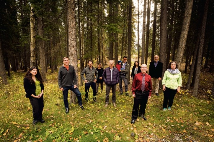 Jessica Clogg, left, Tim Gray, Ed Whittingham, Justina Ray, Devin Page, Mark Butler, Eleanor Fast, Eric Bebert-Daly, Sidney Ribaux and Gretchen Fitzgerald stand in the woods