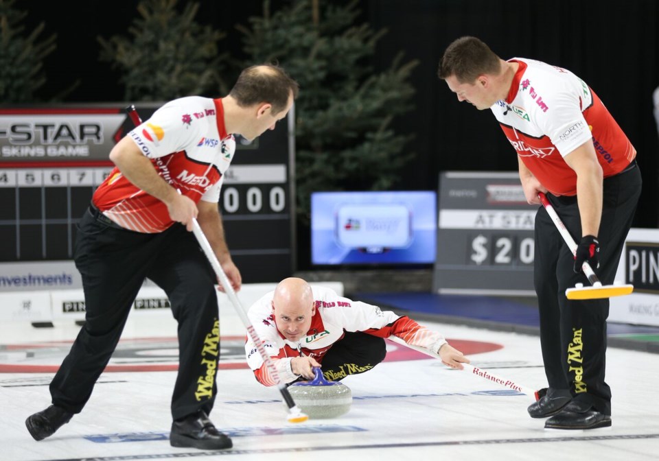 Kevin Koe, throwing, with front end Brent Laing, left and Ben Hebert, right, won the Pinty’s All-Star Curling Skins Game, Sunday (Feb. 5).